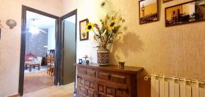 una habitación con un jarrón de flores encima de un tocador en Casa rural en naturaleza con BBQ, en Villar de Cañas