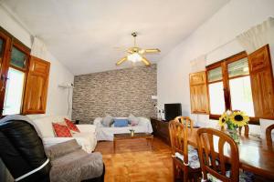 a living room with a couch and a ceiling fan at Casa rural en naturaleza con BBQ in Villar de Cañas