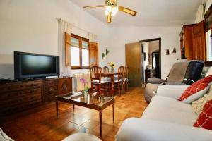 een woonkamer met een bank, een tv en een tafel bij Casa rural en naturaleza con BBQ in Villar de Cañas