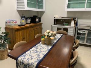 a kitchen with a wooden table with flowers on it at BAAN OZONE HY2 in Hat Yai
