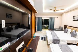 um quarto de hotel com duas camas e um sofá em Aheri Residency em Digha
