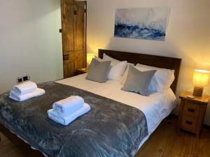 a bedroom with a bed with two towels on it at Market House, Mousehole in Mousehole