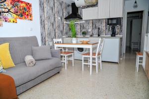 Apartamento El Sendero في البوسكي: غرفة معيشة مع أريكة وطاولة ومطبخ