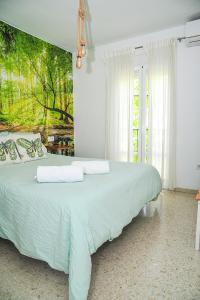 um quarto com uma cama com um quadro na parede em Apartamento El Sendero em El Bosque