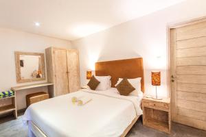 een slaapkamer met een groot wit bed en een spiegel bij Villa Jalak in Seminyak