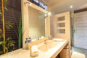 een badkamer met een wastafel en een grote spiegel bij Villa Jalak in Seminyak +25 foto's