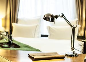 
a lamp sitting on top of a wooden desk at Brown TLV Urban Hotel a member of Brown Hotels in Tel Aviv

