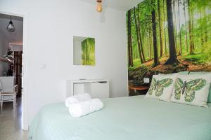 sypialnia z zielonym łóżkiem z poduszkami motyla w obiekcie Apartamento El Sendero w mieście El Bosque +8 zdjęć