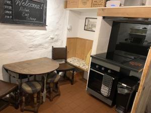 a kitchen with a table and a stove and a table at Market House, Mousehole in Mousehole