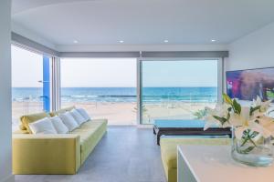 a living room with a yellow couch and a view of the beach at Marbell in Gandía