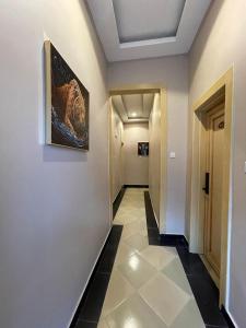un pasillo con suelo de baldosa y una pintura en la pared en Rosa Hotels, en Dodoma