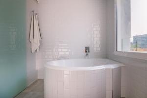 a white bathroom with a tub and a window at Marbell in Gandía