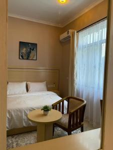 1 dormitorio con 1 cama, 1 mesa y 1 silla en Rosa Hotels, en Dodoma