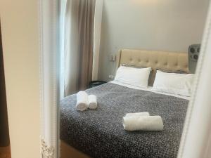 1 dormitorio con 1 cama con 2 toallas en Royal Red suite No2 PIRAEUS PORT en Piraeus