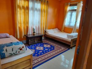 a small room with two beds and a window at Seyon Homestay in Kalimpong