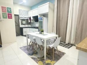 eine Küche mit einem weißen Tisch und weißen Stühlen in der Unterkunft SH Homestay Perlis in Kangar