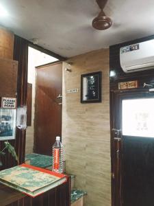 a room with a table and a tv on the wall at New Asian Dormitory in Mumbai