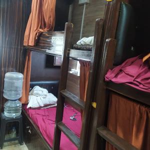 a room with a bunk bed and a ladder at New Asian Dormitory in Mumbai