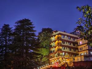 a tall building with lights on it at night at Hotel Taj Palace near Mall Road in Shimla
