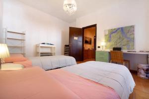 a bedroom with two beds and a desk at Appartamento House of Roses con vista Duomo in Como