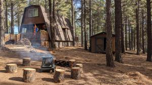 une cabane en rondins dans les bois avec une cuisinière dans l'établissement Friar Tuck Cottage - Close to Williams, Flagstaff and the Grand Canyon, à Williams