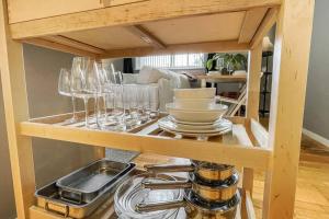 a cabinet with wine glasses and dishes on it at Lofty Apartment in Plymouth in Plymouth