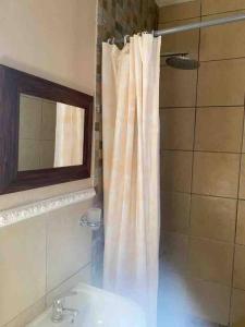 a bathroom with a shower curtain and a sink at Flat in Rustenburg in Rustenburg