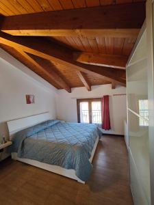 a bedroom with a bed in a room with wooden ceilings at La casetta del borgo in Medicina
