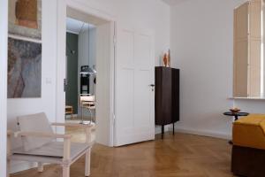 ein Wohnzimmer mit einem Stuhl und einem Tisch in der Unterkunft Design Apartments Weimar Altstadt in Weimar