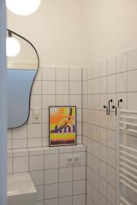 a bathroom with a framed painting on a wall at Design Apartments Weimar Altstadt in Weimar
