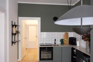 cocina con fregadero y fogones horno superior en Design Apartments Weimar Altstadt en Weimar