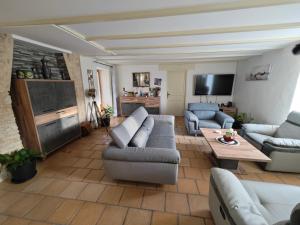 un soggiorno con 2 divani e una TV di Les volets bleus a Doudrac