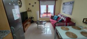 a living room with a red couch and a table at Apartamento Alentía in Cedeira
