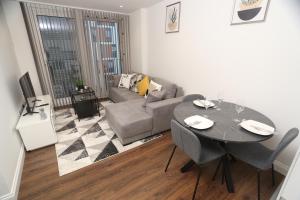 - un salon avec une table et un canapé dans l'établissement Central Watford Apartment, à Watford