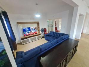 a living room with a blue couch and a tv at Quartos em londrina, tv e ventilador in Londrina
