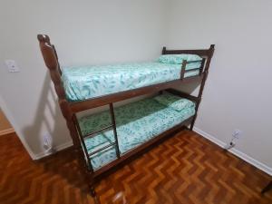 a couple of bunk beds in a room at Quartos em londrina, tv e ventilador in Londrina