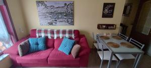 a living room with a pink couch and a table at Apartamento Alentía in Cedeira