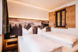 1 dormitorio con 2 camas y ventana en Appartement Hotel Garni Alpenstüble, en Mittelberg