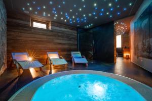 - un bain à remous dans une pièce avec des chaises et des lumières dans l'établissement Ca' Leonardi - Valle di Ledro, à Ledro