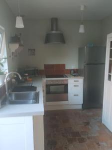 a kitchen with a sink and a stainless steel refrigerator at la grange Saint Georges in Hermaville