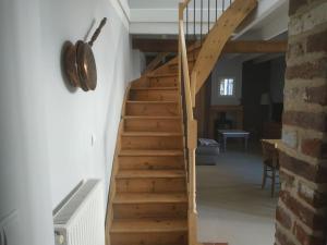 una escalera de madera que conduce a una sala de estar. en la grange Saint Georges, en Hermaville