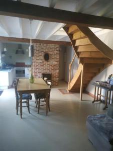 cocina y comedor con mesa y escaleras en la grange Saint Georges, en Hermaville