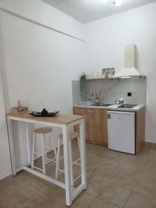 eine Küche mit einer Theke, einem Tisch und einem Waschbecken in der Unterkunft DANDOLOS STUDIOS in Parga