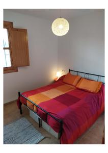 1 dormitorio con 1 cama grande con una manta colorida en RS HAZA DE DOÑA ANA en Picena