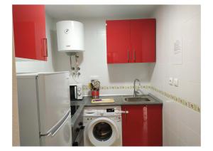 cocina con armarios rojos y lavadora en RS HAZA DE DOÑA ANA en Picena