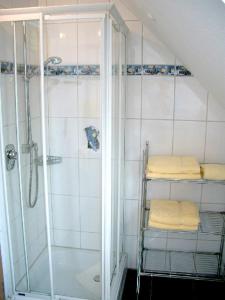 bagno con doccia e 3 asciugamani pieghevoli di Ferienwohnung Keller a Hagnau
