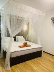 a bedroom with a canopy bed with two teddy bears on it at Sky Garden Ella in Ella
