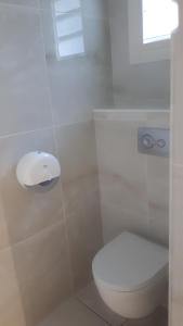 een witte badkamer met een toilet en een raam bij Lala location Le Moule in Le Moule
