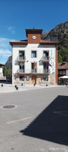 a large white building with a clock on it at Ceraca in Pola de Somiedo