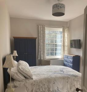 1 dormitorio con 1 cama con cómoda azul y ventana en North Clifton Hall en North Clifton
